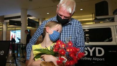 Grandfather and grandaughter embrace at Sydney Airport