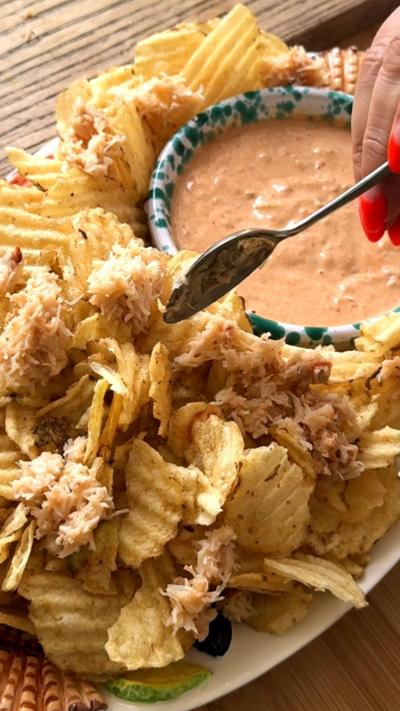Crab loaded crisps with a bowl of dip.
