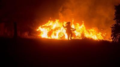 A firefighter lights a backfire while battling the so-called Rocky fire near Clearlake Oaks, California