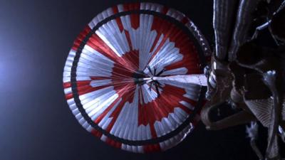 A white parachute with red markings used by the Perseverance rover during its descent to Mars