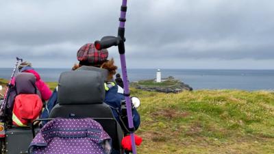 Mobility scooter user looking at a lighthouse in the distance