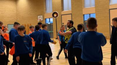 Cuid de sgoilearan Sgoil Mhicneacail agus PC Dòmhnall Steele san talla-spòrs.