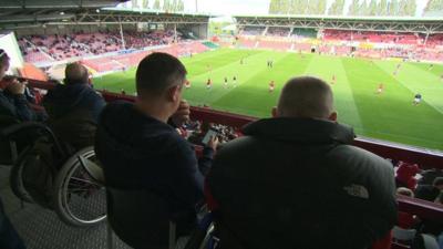 Disabled fans watch a football match