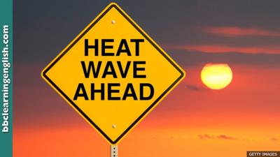 A yellow-diamond sign with 'Heatwave ahead' printed on it in front of a blazing hot yellow sun