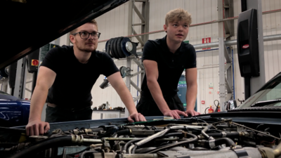 Two apprentices working on a Jaguar