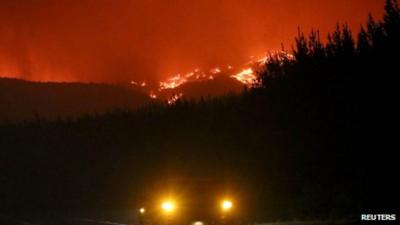 Car approaches wildfires in mountains