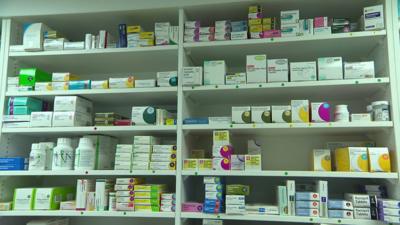 Boxes of medicines and tablets on shelves in a pharmacy