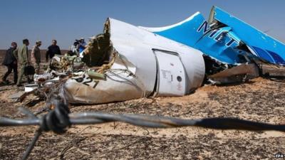 A handout picture from the Russian Emergency Ministry shows Russian Emergency Situations Minister Vladimir Puchkov (4-L) and unidentified officials near a piece of wreckage of Russian MetroJet Airbus A321 at the site of the crash in Sinai