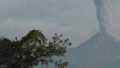 Erupting volcano sending a column of ash and vapour into the air