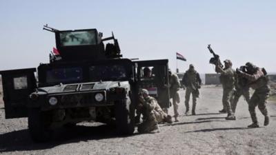 Iraqi police forces outside the town of Abu Saif