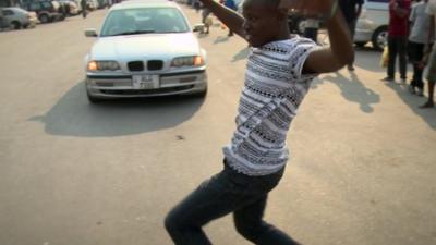 Man dancing in front of car