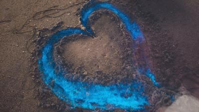 A neon blue heart in the sand