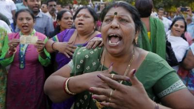 A woman protests over the denomination change