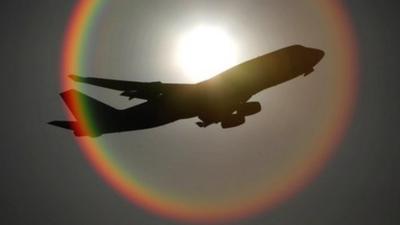 File image of an aeroplane flying in front of the sun as it departs Heathrow airport