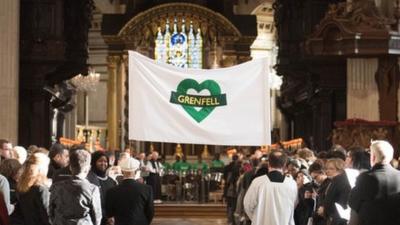 A Grenfell banner being carried into the cathedral