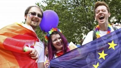 People hold an European Union flag as they take part in the annual Pride London Parade