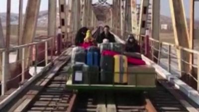 Russians cheering as they exit North Korea on trolley