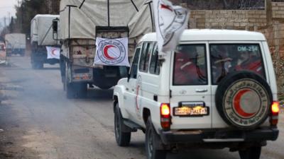 Vehicles from the Syrian Arab Red Crescent drive in a convoy on the outskirts of the besieged rebel-held Syrian town of Madaya, on January 11, 2016.