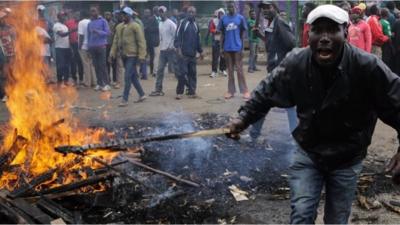 A protester in Nairobi light a stick on fire