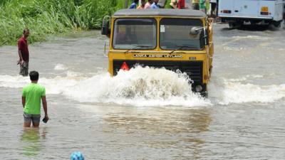 Sri Lankan commuters drive through floodwaters in Colombo