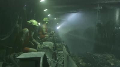 Miners in a deep pit coal mine