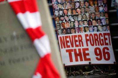 Liverpool FC scarf and poster of victims of Hillsborough disaster bearing the text Never Forget the 96