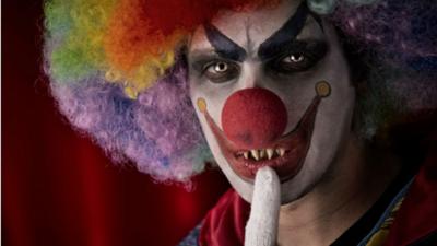 A man wearing scary clown make up glaring directly to camera