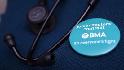 File photo showing a doctor wearing a badge next to her stethoscope