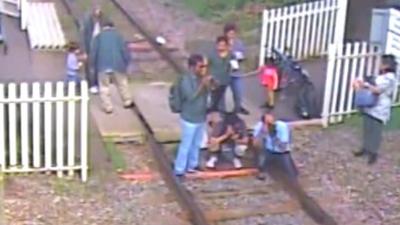 People taking pictures on a train track