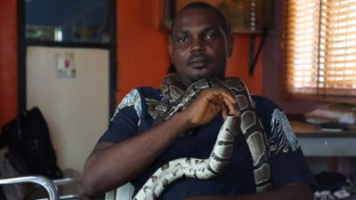 Mark Ofua with a python round his neck