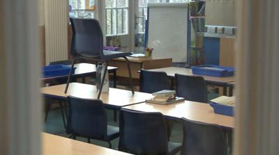 An empty classroom, desks stacked on tables