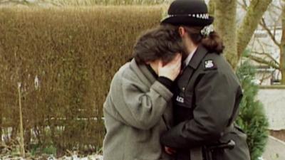 Police office comforting woman