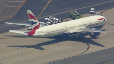 A British Airways plane is surrounded by emergency service vehicles on the runway at Newark International Airport