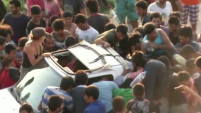 Migrants surrounding car