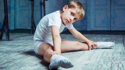 boy-stretching-in-dance-studio