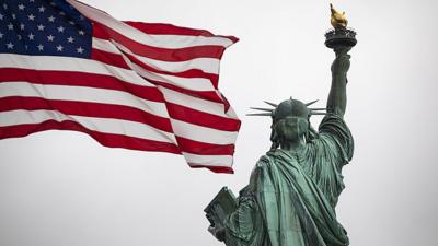 The Statue of Liberty and a US flag