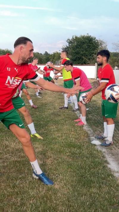 footballers training in red tops, green shorts and white socks
