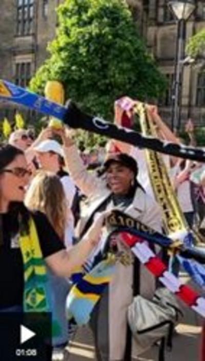 A group of people holding football scarves in the air