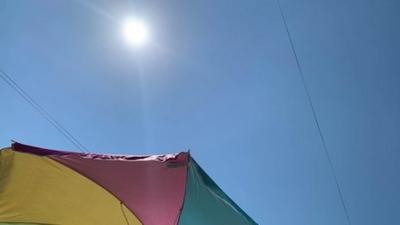 A colourful umbrella offers some shade from the sun