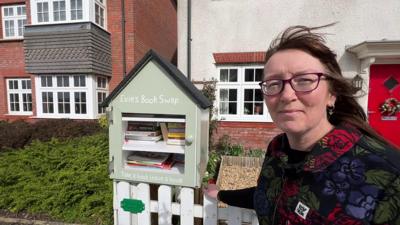 Leanne Hames with the book swap unit, in the shape of a small house