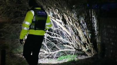 Police use torch to comb through local area to find signs of the missing baby