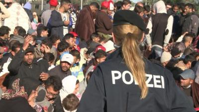 Austrian police officer watches over migrants and refugees