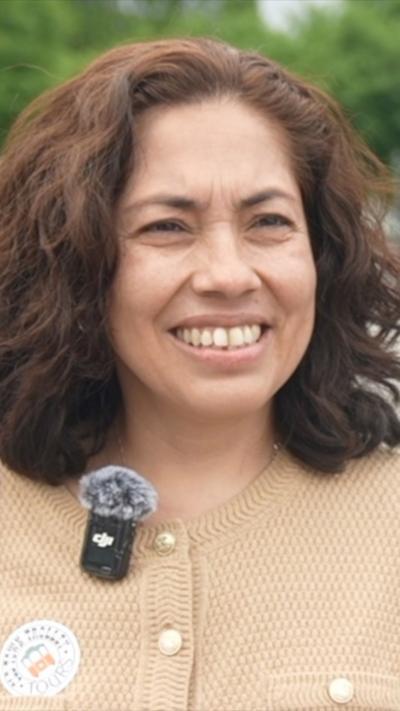 A woman looks to the right as she is being interviewed