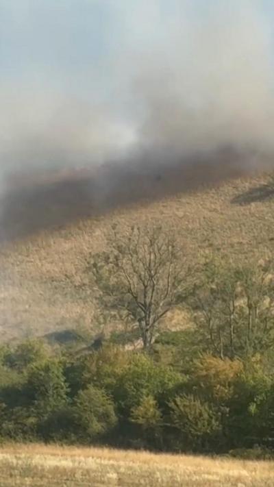 Smoke spread across yellow grass.