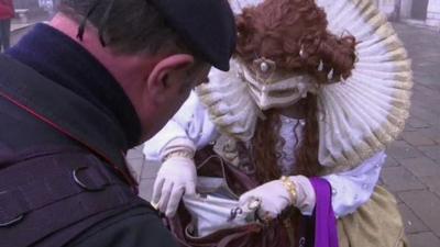 A woman having her bag checked at the annual carnival in Venice.