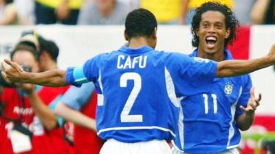 Ronaldinho celebrates his goal against England with Cafu