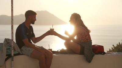 Two people sitting in front of the coast