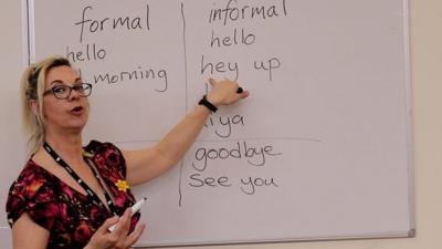 The teacher pointing at 'hey up' on a whiteboard.