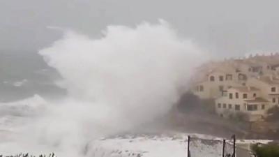 Waves crash against houses on Spanish coast