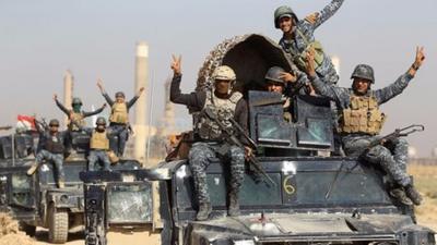 Iraqi forces make victory signs after taking control of a refinery on the outskirts of the city of Kirkuk on 16 October 2017